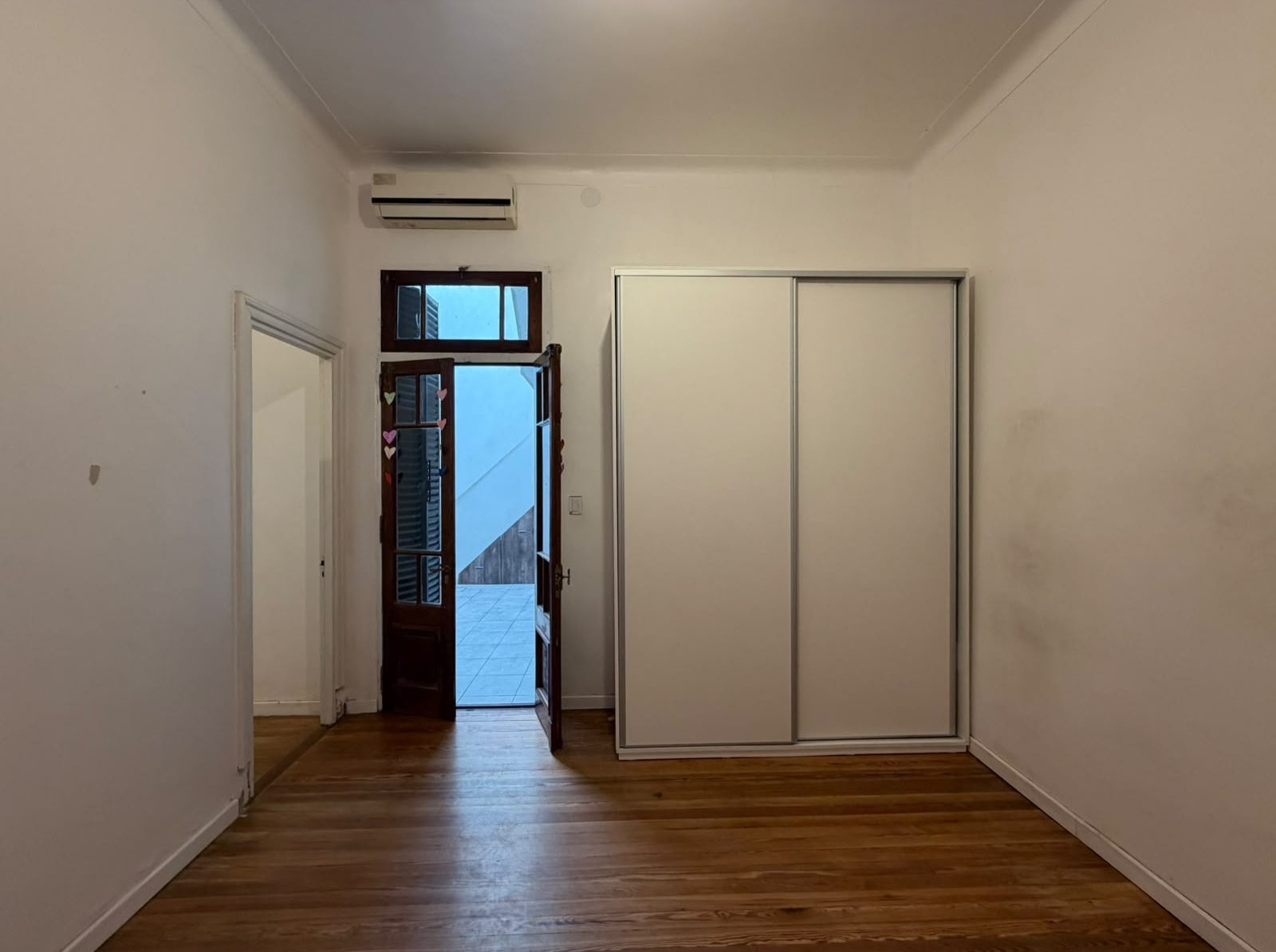 Antes: el cuarto con paredes blancas, placard blanco y aire acondicionado