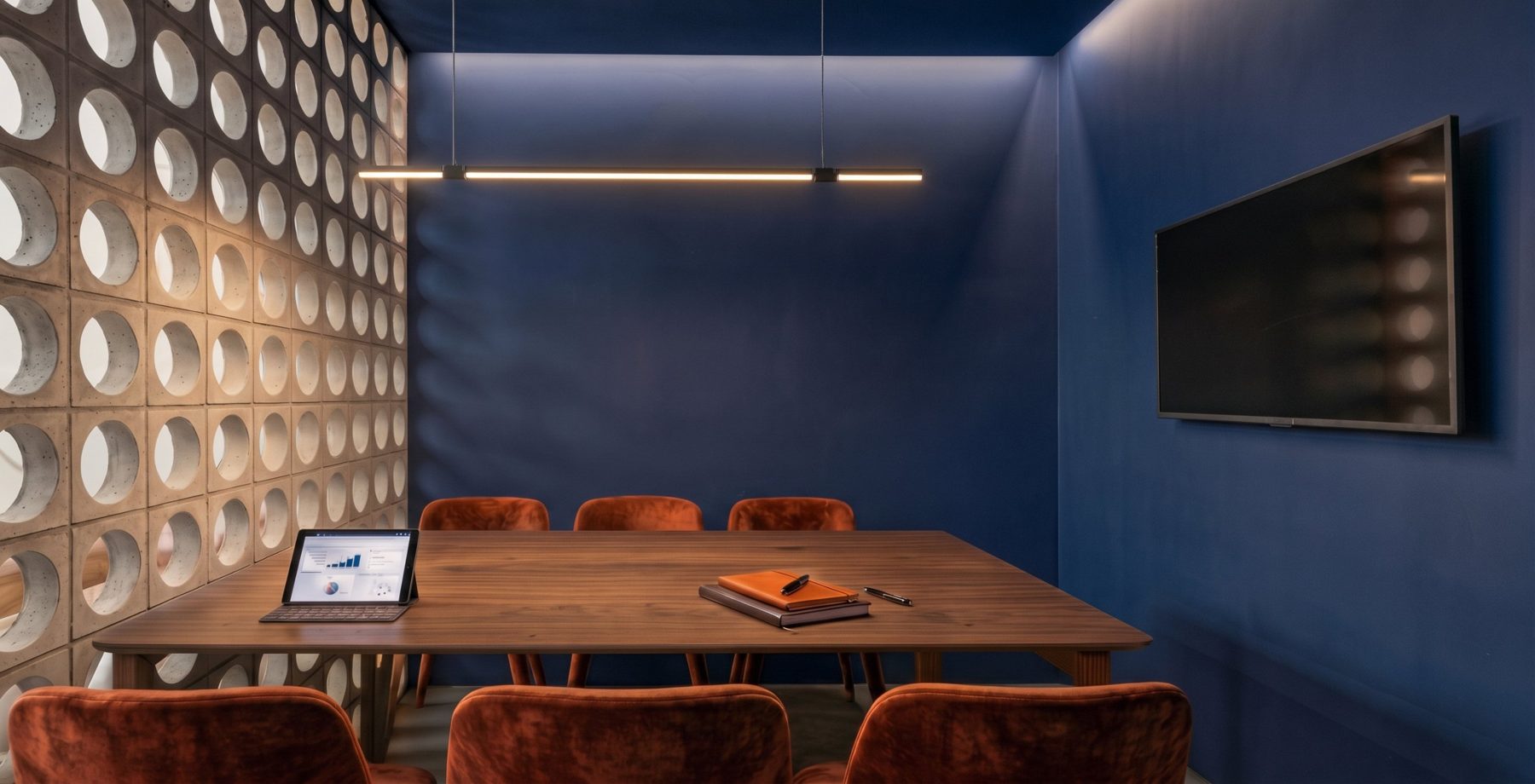 Propuesta: sala de reuniones azul con celosía cerámica terracota iluminada, mesa de madera y sillas de terciopelo